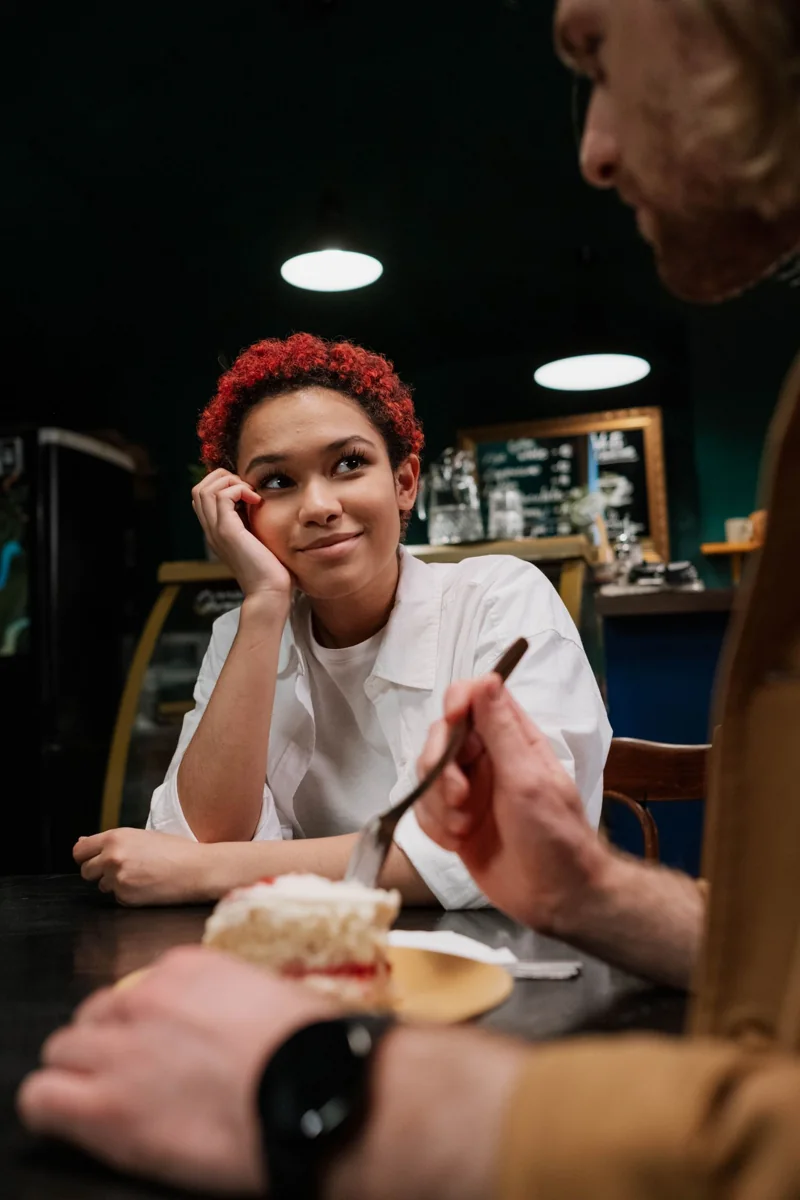 Dos adultos comparten una conversación en una cafetería